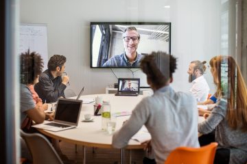 Multi-ethnic businessmen and businesswomen having video conference meeting in board room at office